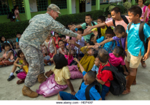 U.S. Army Chaplain, Capt. Ryan Mortensen, assigned to 1st Battalion, 27th Infantry Regiment, 2nd BCT, 25th Infantry Division, meets with local school children to learn about the difference in American and Thai culture during a humanitarian aid mission in Lopburi province, Thailand, Feb. 16, 2015. The mission was carried out as a part of the joint-training operation Cobra Gold 2015. (U.S. Army photo by Spc. Steven Hitchcock/Released) Cobra Gold 2015 150216-A-SE706-168